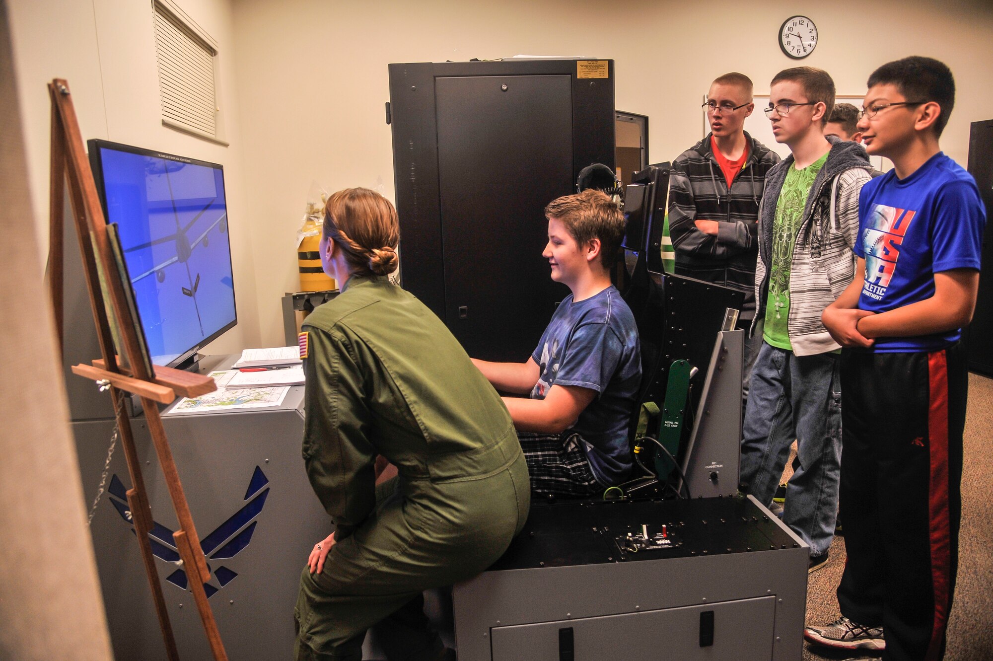 Staff Sgt. Bethany Whiteley, 92nd Aerospace Medicine Squadron aerospace and operational physiology craftsman, shows students from Medical Lake High School Junior ROTC how to pilot an aircraft in the training simulator during a tour May 4, 2015, at Fairchild Air Force Base, Wash. The students had the opportunity to see what it would be like to be a pilot and take off in an aircraft. (U.S. Air Force photo/Airman 1st Class Taylor Bourgeous)