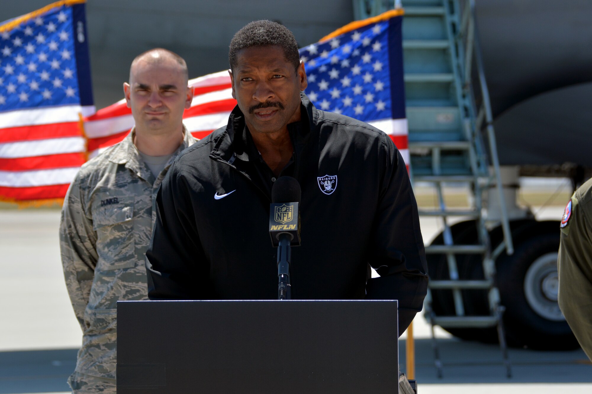 Napoleon McCallum, a graduate of the U.S. Naval Academy and Oakland Raiders legend, announces the name of a player selected by the Oakland Raiders May 2, 2015, during Day 3 of the NFL Draft, at Travis Air Force Base, California. (U.S Air Force photo by Senior Airman Charles Rivezzo)