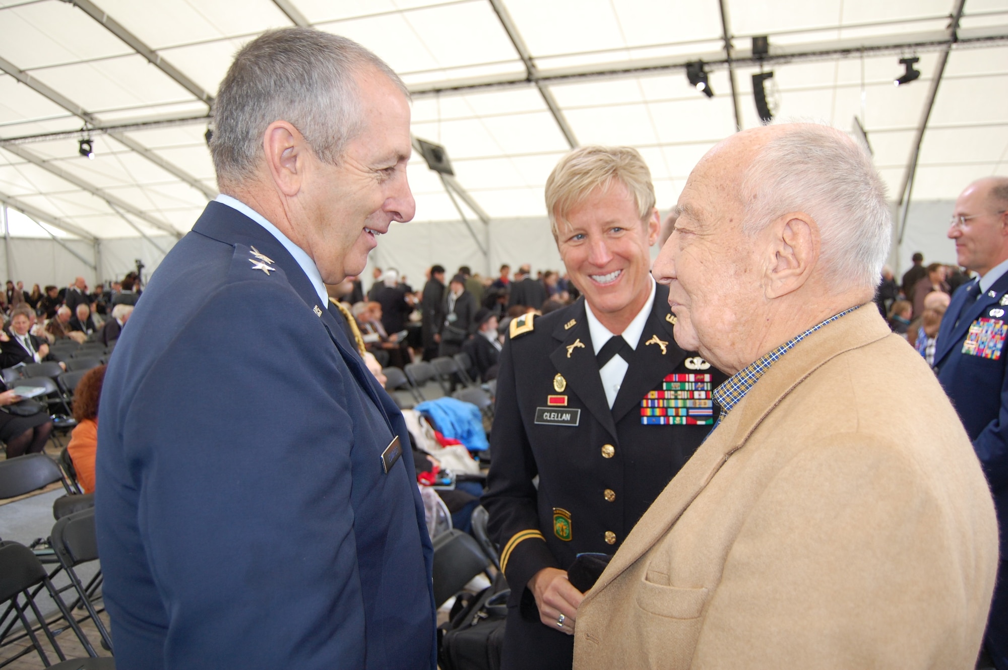 Maj. Gen. H. Michael Edwards, the Adjutant General of Colorado, and Col. Laura Clellan, Land Component Commander for the Colorado Army National Guard, listen attentively to one of the survivors of Dachau Concentration Camp prior to the commemorative ceremony for the 70th anniversary of the liberation of Dachau May 3. Members of these National Guard units participated in various ceremonies May 1-3, 2015 to honor the fallen and share the experience of the survivors and liberators. The 157th Infantry Regiment, one of the units that liberated the camp on April 29, 1945, initially mustered from the state of Colorado. The regiment was a subordinate unit to the 45th Infantry Division, initially formed in Oklahoma. (Air National Guard photo by Capt. Kinder Blacke)
