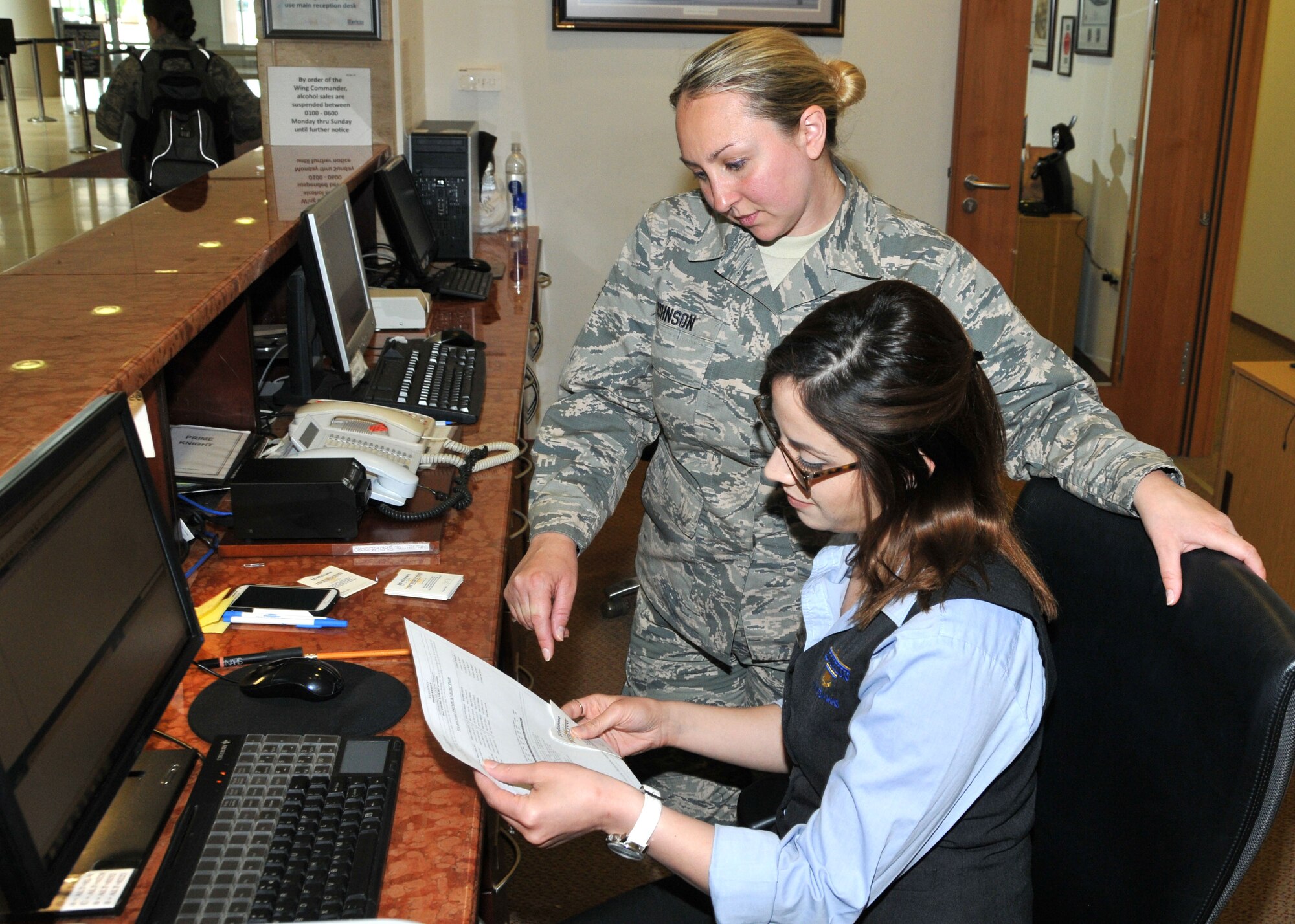 Staff Sgt. Adrianne Johnson, 104th Services Flight, Barnes Air National Guard Base, Westfield, Mass., receives training on front desk procedures from Ayesgui Gignac, Guest Services Representative, May 7, 2015, on the front desk computer system, Air Force Inn, Kaiserslautern Military Community Center, Ramstein Air Base, Germany. Johnson trained at the KMCC Air Force Inn May 5-7 in the areas of housekeeping, inspecting rooms, accounting, reservations, and supply, allowing her to sign off on requirements for her services position. (U.S. Air National Guard photo by Tech. Sgt. Melanie J. Casineau/ Released)