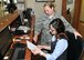 Staff Sgt. Adrianne Johnson, 104th Services Flight, Barnes Air National Guard Base, Westfield, Mass., receives training on front desk procedures from Ayesgui Gignac, Guest Services Representative, May 7, 2015, on the front desk computer system, Air Force Inn, Kaiserslautern Military Community Center, Ramstein Air Base, Germany. Johnson trained at the KMCC Air Force Inn May 5-7 in the areas of housekeeping, inspecting rooms, accounting, reservations, and supply, allowing her to sign off on requirements for her services position. (U.S. Air National Guard photo by Tech. Sgt. Melanie J. Casineau/ Released)