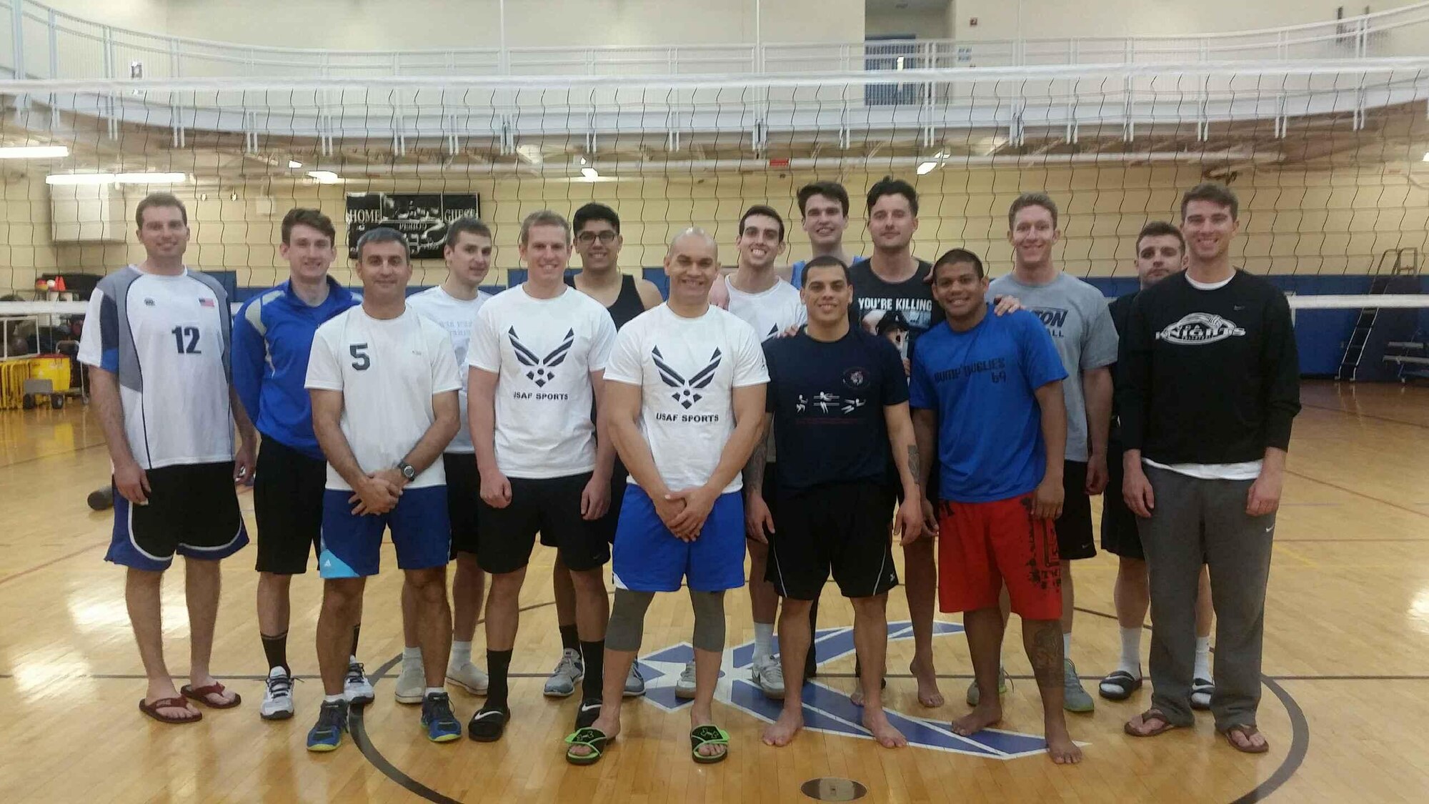 Senior Airman Jan C. Flores, 9th Aircraft Maintenance Squadron radio frequency technician (center) and fellow selectees for the All-Air Force Men's Volleyball Trial Camp pose for a photo on the Air Force training court at Hanscom Air Force Base, Mass., May 6, 2015. Airmen who earn a spot on the final team will go on to represent the Air Force at the Armed Forces National Men’s Volleyball Championship in Detroit, May 22 to 27, 2015. (Courtesy photo)