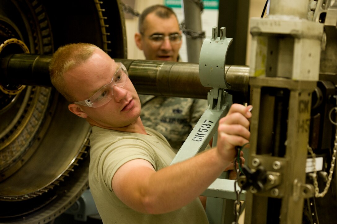 Tech. Sgt. Lyndon Fontenot, 361st Training Squadron instructor, supervises Airman Joshua Perreault, 361st Training Squadron student, in removing low pressure turbine from the F-100/110 engine May 7, 2015. Students learn how to remove, inspect and install the low pressure turbine for the major assembly. (U.S. Air Force photo by Danny Webb/Released)
