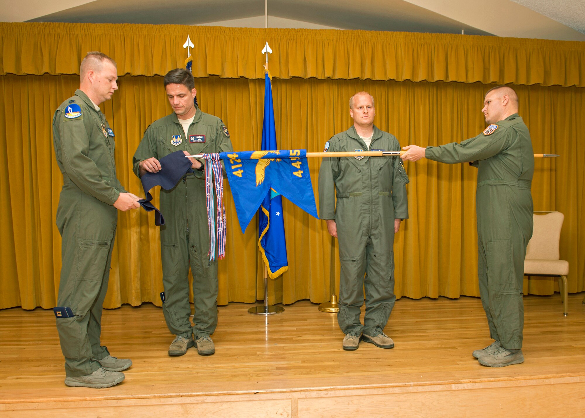 Col. Rodney Todaro (second from left), 412th Operations Group commander, cases the 445th Flight Test Squadron flag as a final symbol of closure to the squadron's history during the 445th FLTS inactivation ceremony held May 1 at Club Muroc. The 445th Flight Test Squadron was consolidated into three other Combined Test Forces. (U.S. Air Force photo by Edward Cannon)