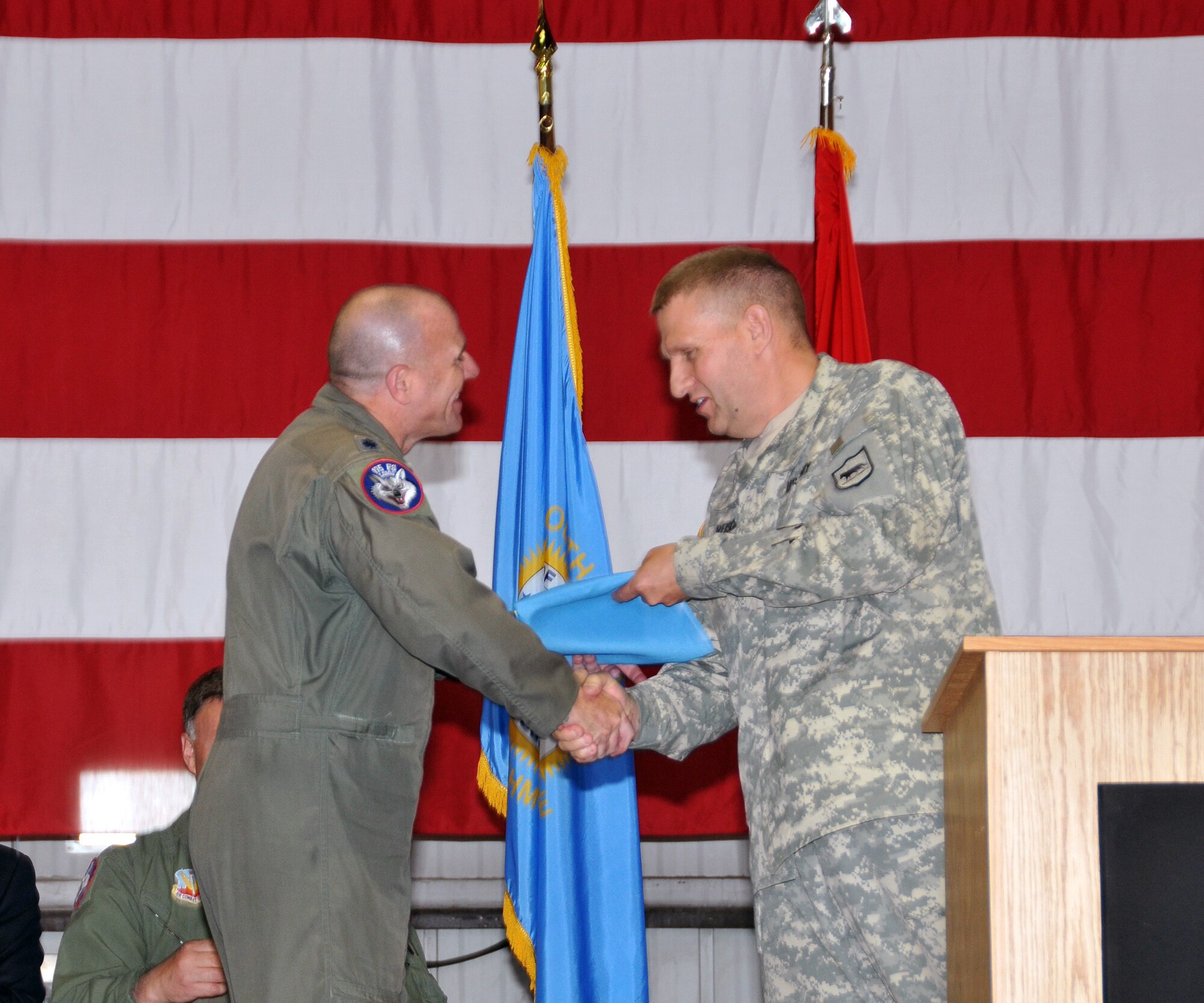 U.S. Air Force Lt. Col. Todd M. Sheridan, 175th Fighter Squadron commander and detachment commander, accepted a South Dakota state flag from Maj. Gen. Tim Reisch, the adjutant general for the South Dakota National Guard, during a mobilization ceremony held at Joe Foss Field, S.D., May 3, 2015. The South Dakota Air National Guard’s 114th Fighter Wing is slated to deploy to South Korea and it is customary that the adjutant general present a state flag to the detachment commander in charge, which he will display at their deployed location. (U.S. Air National Guard photo by Tech. Sgt. Christopher Stewart)