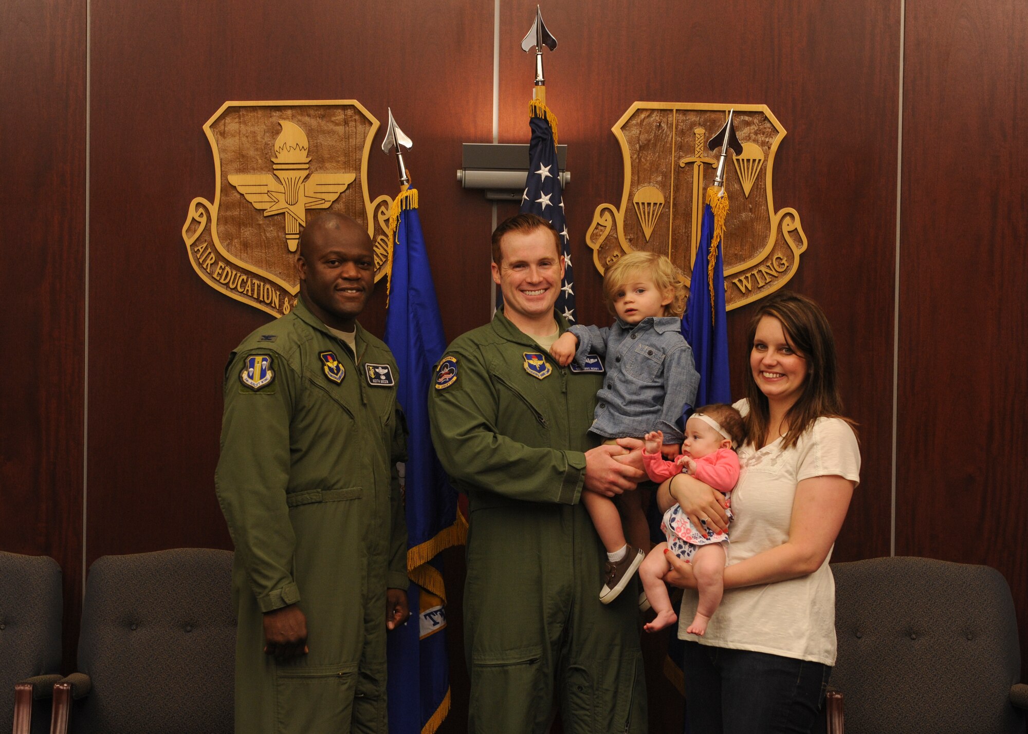 Col. Keith Green, 314th Airlift Wing vice commander, congratulates Staff Sgt. Michael Berry, 62nd Airlift Squadron formal training unit instructor loadmaster, and his family on his selection as Combat Airlifter of the Week May 4, 2015, at Little Rock Air Force Base, Ark. Berry strengthened Total Force Integration partnerships by overseeing the completion of seven upgrade training events for a 189th Airlift Wing loadmaster and he also earned the highly coveted title of Master Instructor by the Community College of the Air Force. (U.S. Air Force photo by Senior Airman Scott Poe)