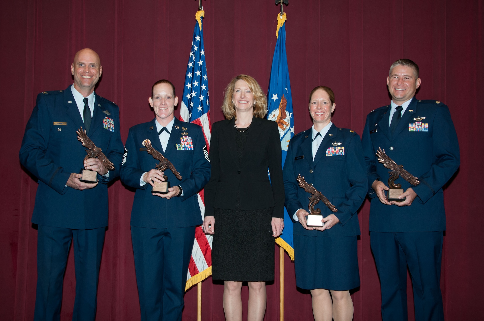 Acting Undersecretary of the Air Force Lisa Disbrow, center, presented the Secretary of the Air Force Leadership Award to two current and two former Air University students during a ceremony at Air War College, May 5, 2015. Receiving the awards were (left to right) Col. Wayne Straw, current AWC student; Marine Corps Master Sgt. Joseph Banas, former Air Force Senior Noncommissioned Officer Academy student (Master Sgt. Jennifer Johnson from the Academy accepted the award on his behalf); Maj. Avery Schutt, current student at Air Command and Staff College; and Capt. Roni Yadlin, former Squadron Officer School student (Lt. Col. Joseph Laws, commander 427th Reconnaissance Squadron, Beale Air Force Base, Calif., accepted the award on her behalf). The annual award recognizes exceptional performance by a student attending one of Air University’s professional military education schools. (U.S. Air Force photo by Bud Hancock/cleared)