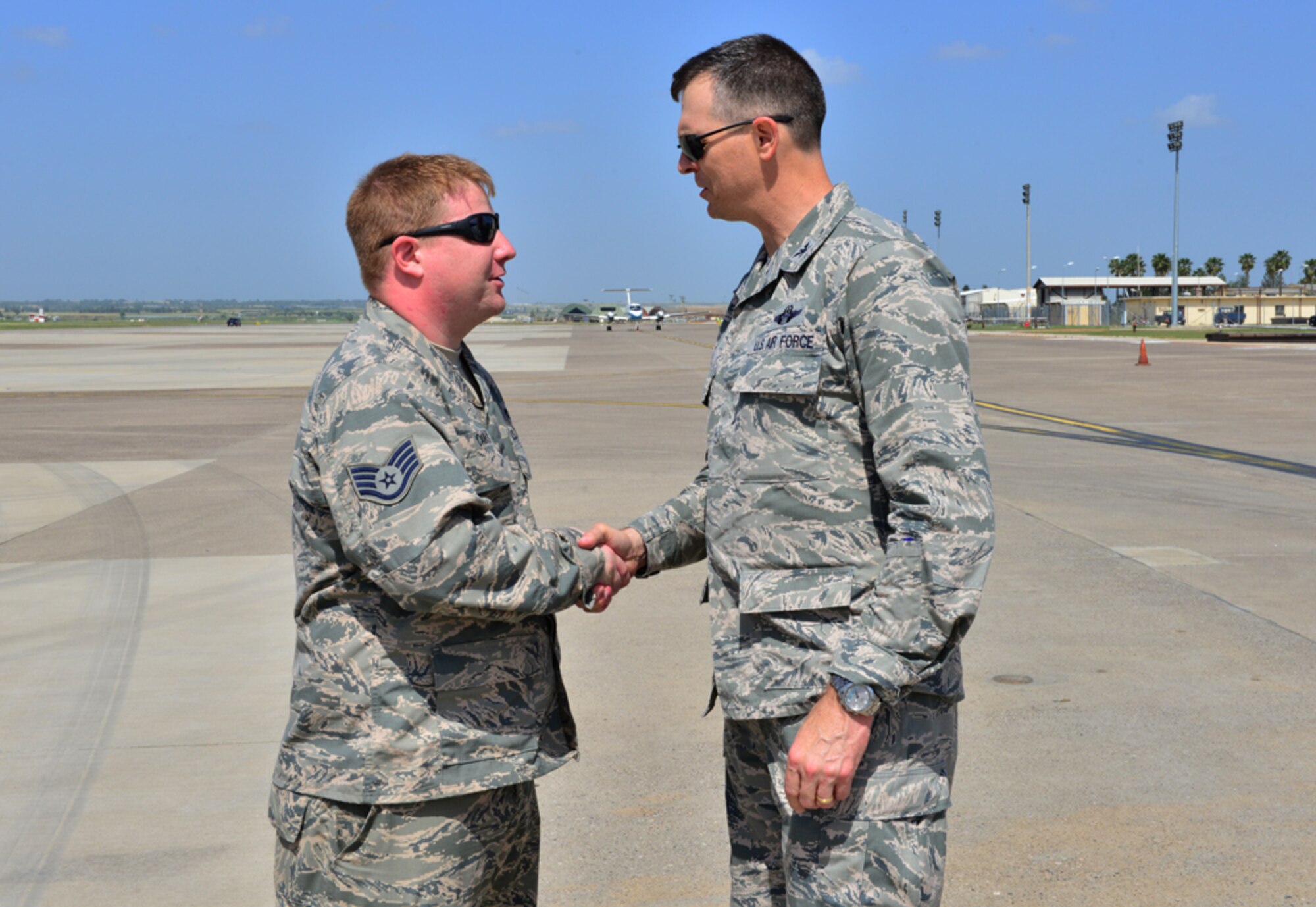 Col. Craig Wills, 39th Air Base Wing commander, coins Staff Sgt. Earnest Caras, 728th Air Mobility Squadron passenger service technician, during a unit visit April 30, 2015, at Incirlik Air Base, Turkey.  Wills meet with Airmen of the 728th AMS as part of the commander’s Out Connecting with Airmen program. (U.S. Air Force photo by Senior Airman Michael Battles/Released) 