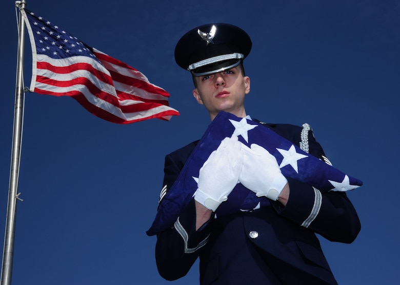 Senior Airman Travis Von Elling, 319th Air Base Wing Honor Guard ceremonial guardsman, poses with the flag May 5, 2015 on Grand Forks Air Force Base, N.D. Von Elling was selected as the Warrior of the Week for the first week of May 2015. (U.S. Air Force photo by Airman 1st Class Ryan Sparks/released)