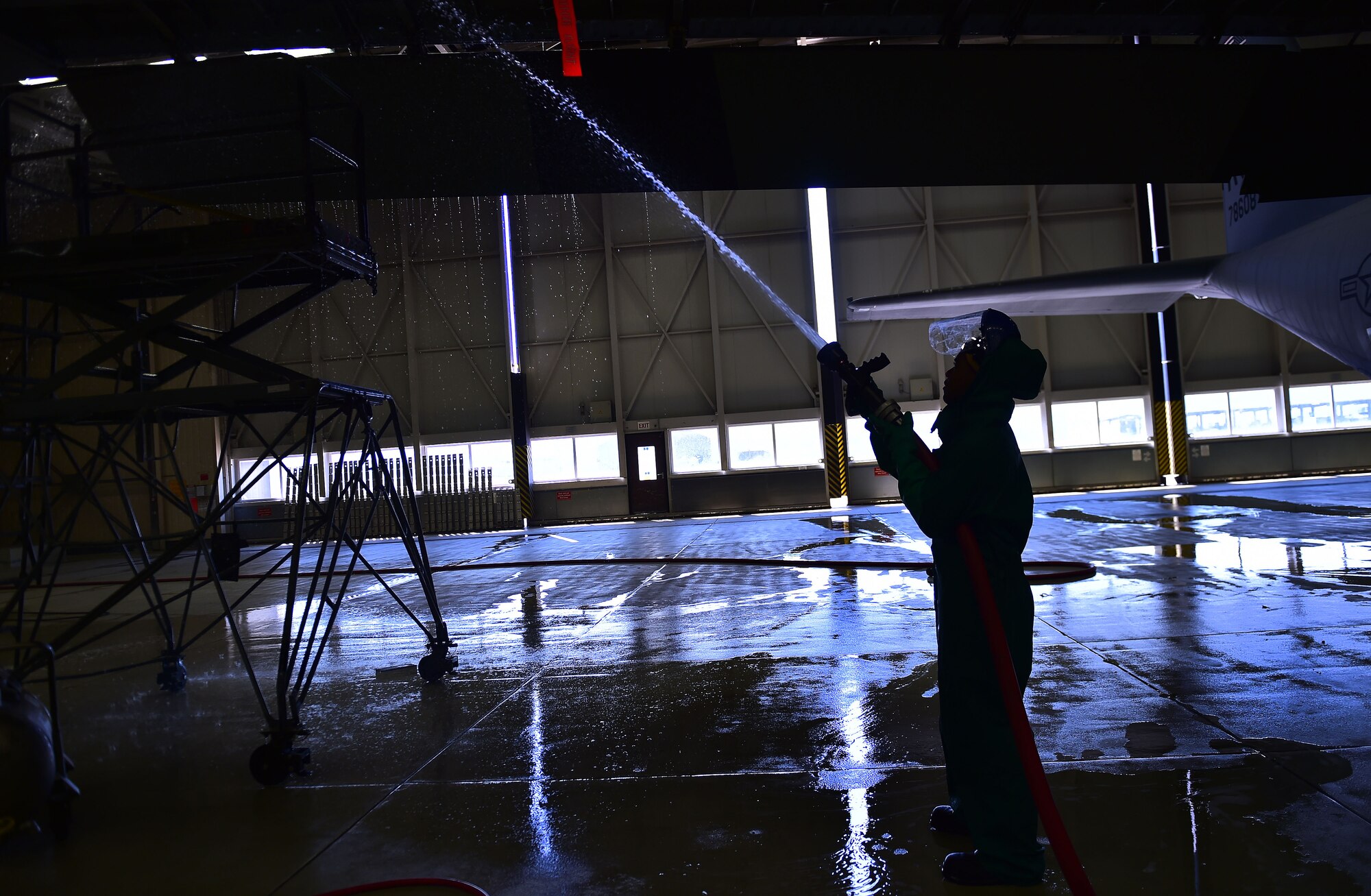 An Airman from the 86th Aircraft Maintenance Squadron rinses a wing of a C-130J Super Hercules with water April 20, 2015, at Ramstein Air Base, Germany. Aircraft washing is a vital part of the flying mission, and if C-130Js are not washed regularly, they can begin to corrode and cause damage yielding it unsafe to operate. As Airmen perform washing procedures, safety is paramount. Airmen are required to wear full-body protective gear during the process. (U.S. Air Force photo/Staff Sgt. Sara Keller)