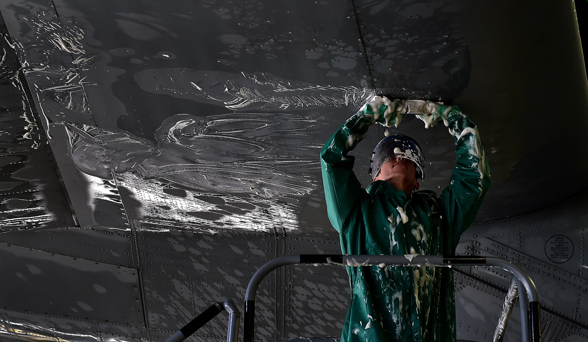 Airman 1st Class Robert Thomson, 86th Aircraft Maintenance Squadron crew chief, washes the tail of a C-130J Super Hercules April 20, 2015, at Ramstein Air Base, Germany. While washing the aircraft, safety is the number one concern for all the Airmen. All members participating in the washing are required to wear full-body protective gear. (U.S. Air Force photo/Staff Sgt. Sara Keller)