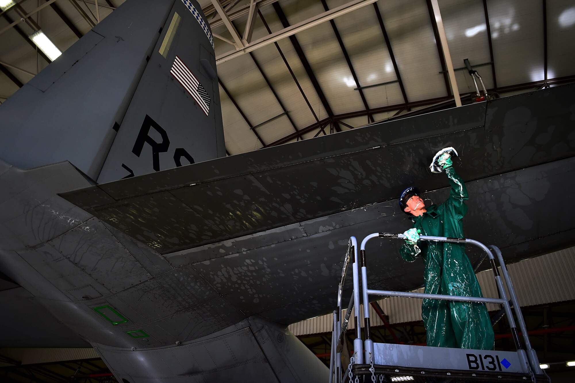 Airman 1st Class Robert Thomson, 86th Aircraft Maintenance Squadron crew chief, washes the tail of a C-130J Super Hercules April 20, 2015, at Ramstein Air Base, Germany. While washing the aircraft, safety is the number one concern for all the Airmen. All members participating in the washing are required to wear full-body protective gear. (U.S. Air Force photo/Staff Sgt. Sara Keller)