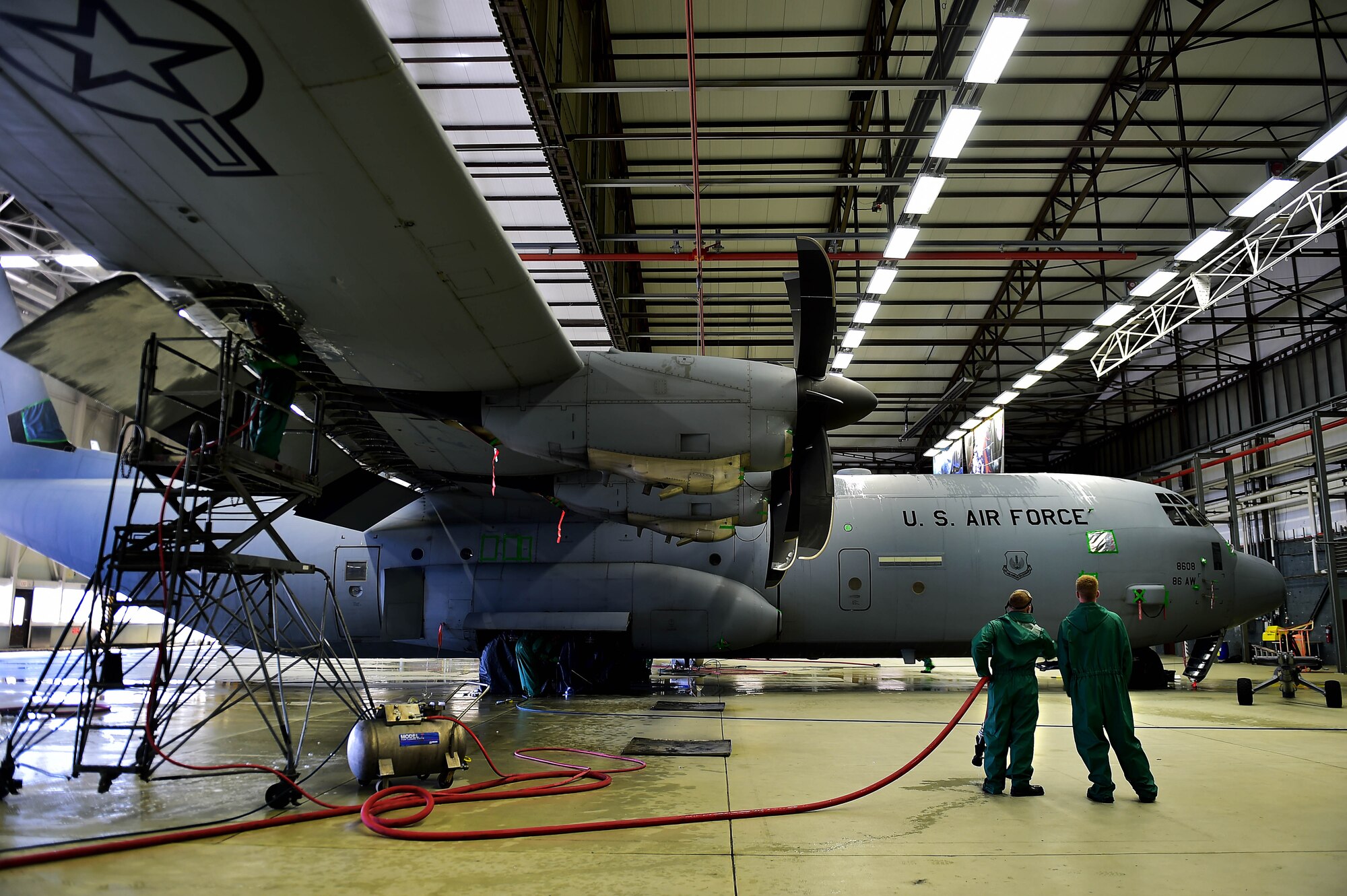 Two Airmen from the 86th Aircraft Maintenance Squadron assess a C-130J Super Hercules before washing it, April 20, 2015 at Ramstein Air Base, Germany. All C-130Js at Ramstein are washed regularly for corrosion prevention and control. Keeping major structural components clean helps improve the life span of aircraft, thus keeping them operational for longer. (U.S. Air Force photo/Staff Sgt. Sara Keller)