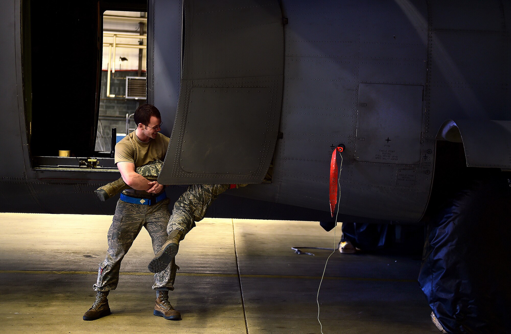 Senior Airman Trenton Strayer, assists his wingman, Senior Airman Stephen Grady, 86th Aircraft Maintenance Squadron crew chiefs, in preparing a C-130J Super Hercules to be washed April 20, 2015, at Ramstein Air Base, Germany. Strayer and Grady helped prepare the C-130J by covering areas of the aircraft to protect it from water and soap. (U.S. Air Force photo Staff Sgt. Sara Keller)