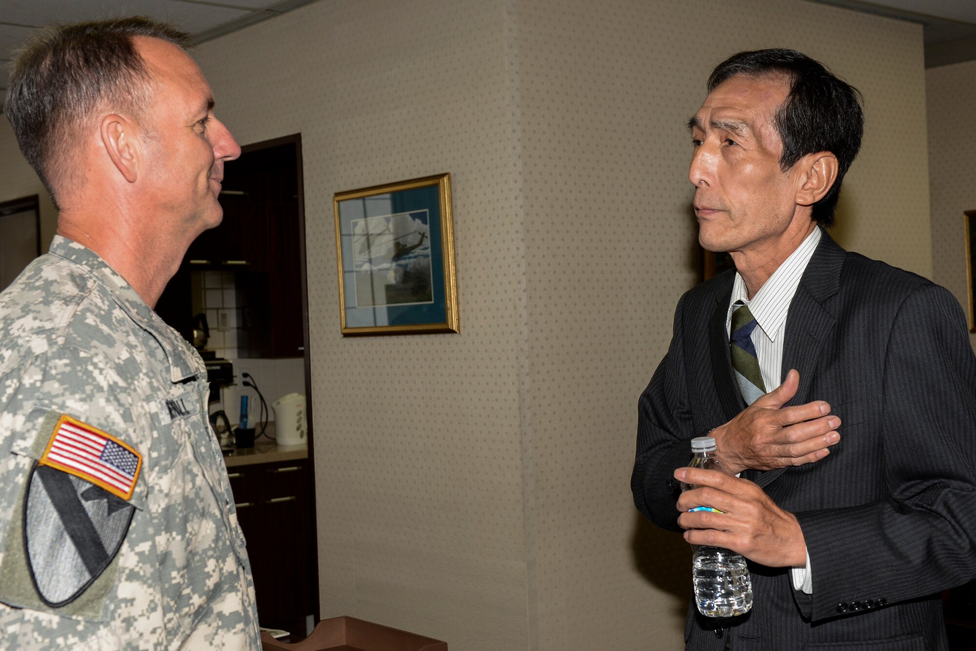 Artist Ikuo Ohsawa holds a commemorative coin to his heart after receiving it from Col. Cory Mendenhall, deputy commander of U.S. Forces, Japan, April 30, 2015 at Yokota Air Base, Japan. Ohsawa said he has a long history with USFJ, reaching back to when he was a hungry child and American forces gave him food. (U.S. Air Force photo by Airman 1st Class Elizabeth Baker/Released)