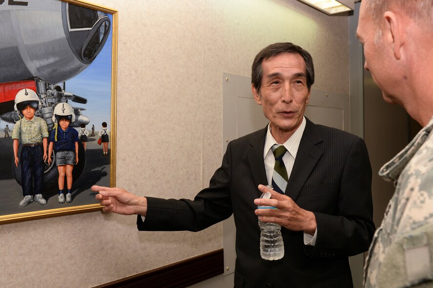 Artist  Ikuo Ohsawa recounts stories to Col. Cory Mendenhall, chief of staff of United States Forces Japan, of what inspired his paintings, April 30, 2015 at Yokota Air Base, Japan. Ohsawa donated over 100 pieces of his art to the 5th Air Force Headquarters when the building opened in 1975. (U.S. Air Force photo by Airman 1st Class Elizabeth Baker/Released)