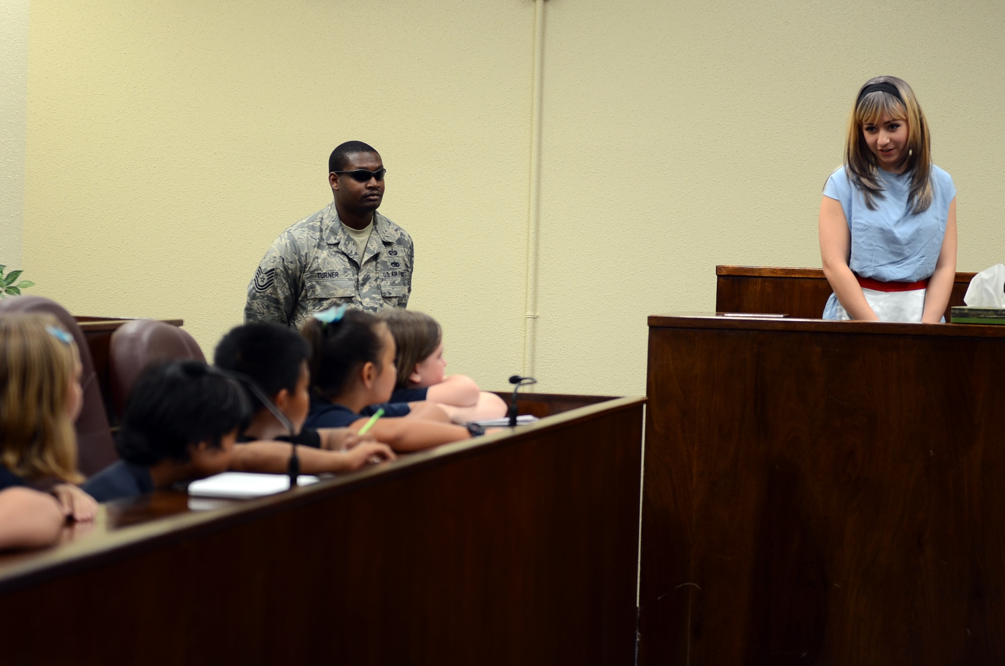 Airman 1st Class Alyssa Moreno, 36th Wing military justice paralegal, testifies to Andersen Elementary School fourth graders as Alice at the base courtroom May 1, 2015, at Andersen Air Force Base, Guam. The 36th Wing Paralegal team acted out an Alice in Wonderland-themed mock trial for Law Day to explain to students the importance of the Magna Carta. (U.S. Air Force photo by Airman 1st Class Alexa Ann Henderson/Released)
