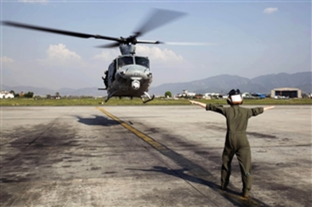 U.S. Marine Corps Cpl. Mackenzie Higgins guides a UH-1Y Huey for takeoff at Tribhuvan International Airport in Kathmandu, Nepal, May 5, 2015. Marines with Marine Light Attack Helicopter Squadron 469 and Marine Medium Tilt Rotor Squadron 262 brought in supplies to Charikot, Nepal that will provide the Nepalese people with shelter after a magnitude-7.8  earthquake struck the country, April 25. 