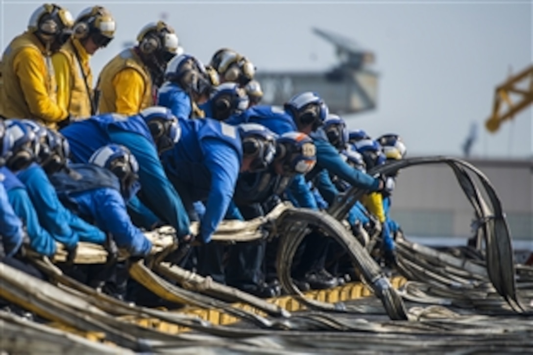Navy sailors stretch out the emergency crash barricade on the flight deck aboard the aircraft carrier USS Harry S. Truman during a general quarters drill in Portsmouth, Va., May 6, 2015. The carrier is acquiring certifications required for its upcoming deployment.