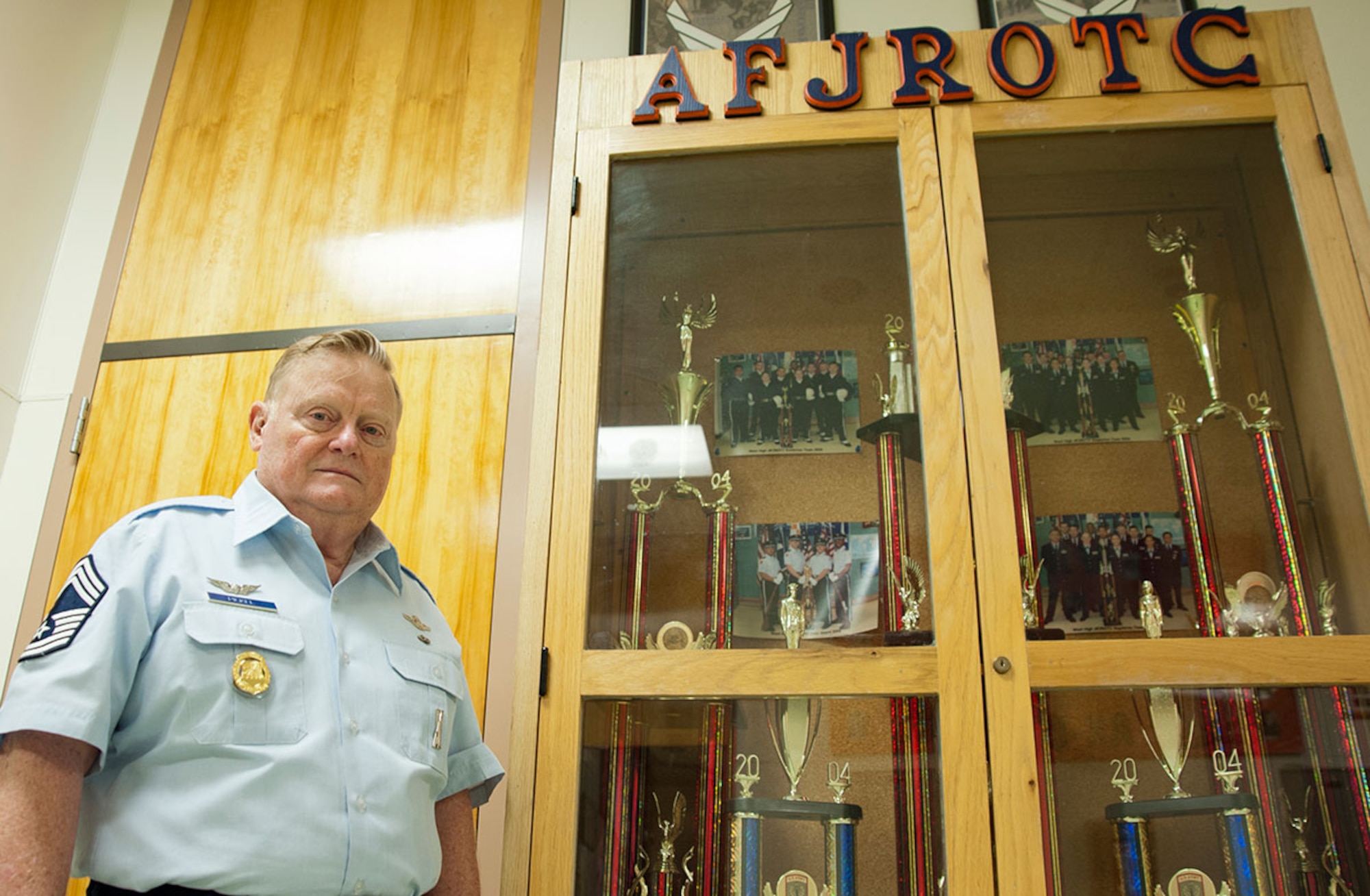 Retired Chief Master Sgt. Morris Pickel, Air Force junior ROTC aerospace science instructor, stands next to an AFJROTC drill trophy case at West Anchorage High School in Anchorage, Alaska, April 29, 2015. Pickel has spent more than 50 years combined in active duty service and as an AFJROTC instructor. His assignment as an AFJROTC instructor was only a five-year contract, but Pickel stayed for more than 20 years. (U.S. Air Force photo/Airman 1st Class Tammie Ramsouer)