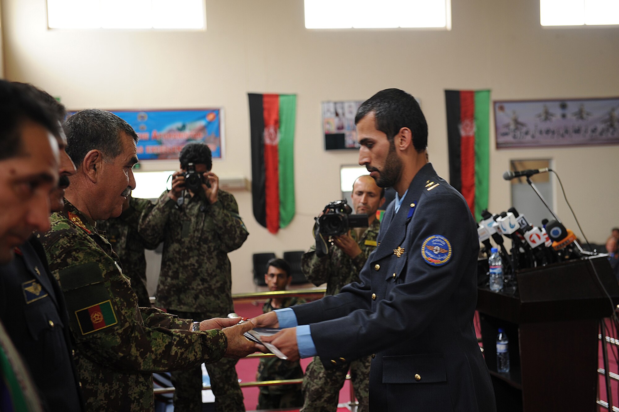 One of the top graduates of the Afghan Air Force academy accepts his diploma and a sword during a graduation ceremony, May 7, 2015. The ceremony marked the first graduation of new Afghan Air Force officers since the fall of the Taliban. (Official U.S. Air Force photo/Capt. Jeff M. Nagan)