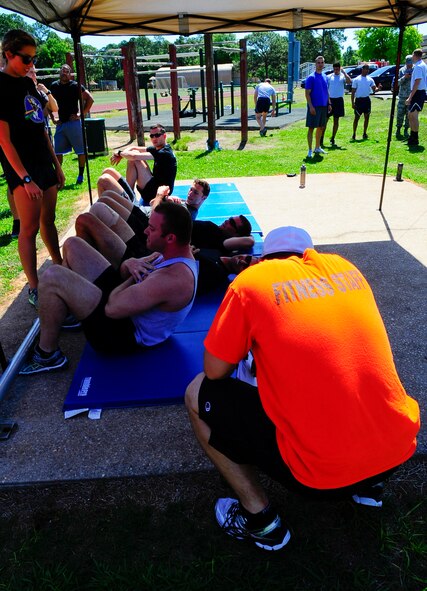 Staff Sgt. Stephen Shrable, 1st Special Operations Force Support Squadron fitness supervisor, monitors Air Commandos during a sit-up competition at Hurlburt Field, Fla., May 6, 2015. Air Force Fitness Month promotes physical wellness and teaches Airmen how being "fit" plays a vital role in the quality of military life. (U.S. Air Force photo/Airman 1st Class Andrea Posey)