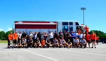Teams pose with a fire truck after participating in the fitness day competition at Hurlburt Field, Fla., May 6, 2015. Air Force Fitness Month promotes physical wellness and teaches Airmen how being "fit" plays a vital role in the quality of military life. (U.S. Air Force photo/Airman 1st Class Andrea Posey)