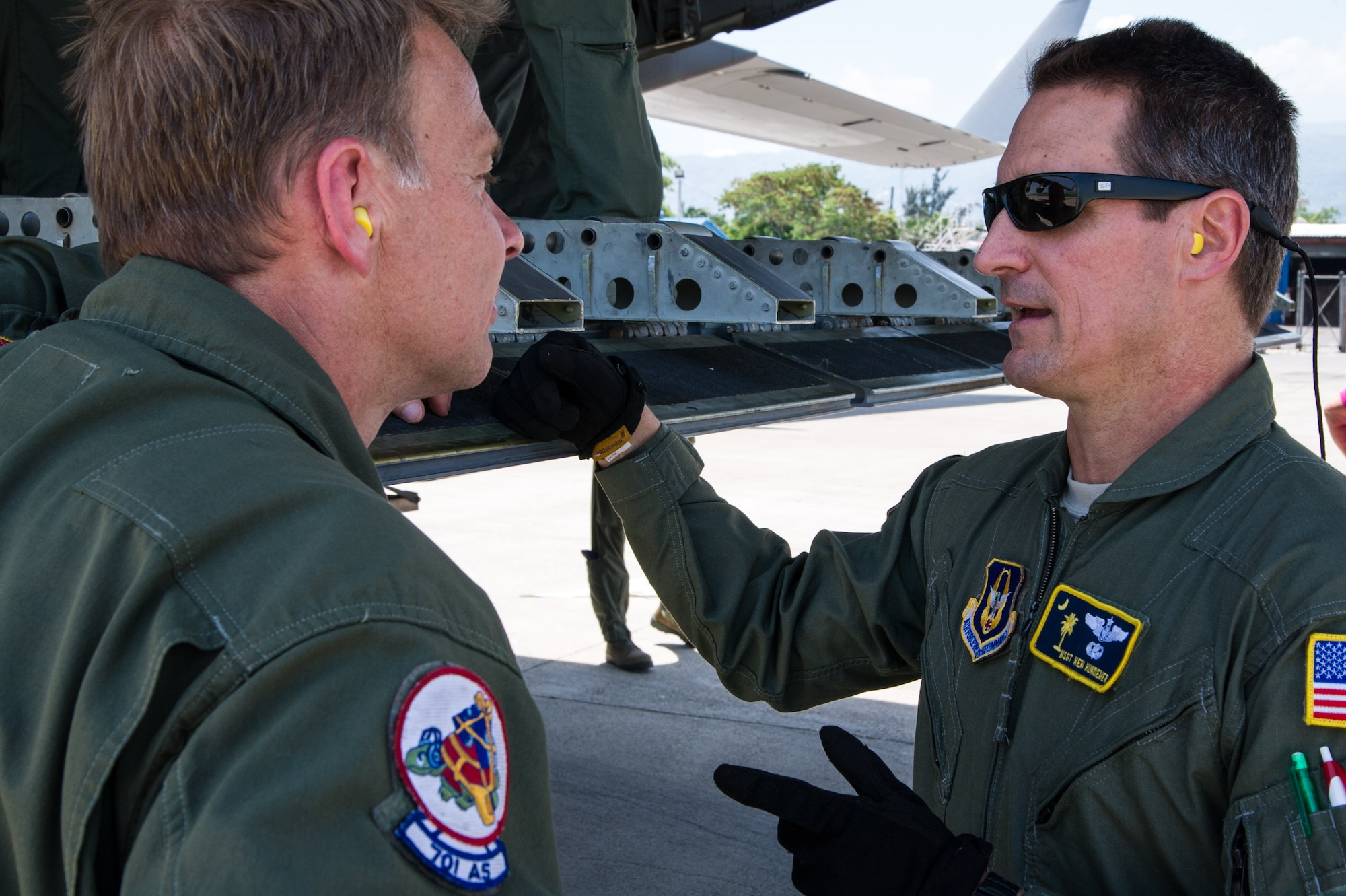 Master Sgt. Ken Hundemer, 317th Airlift Squadron loadmaster, discuses cargo offload operations with Master Sgt. Don Rix, 701st Airlift Squadron loadmaster, in Haiti April 23, 2015 during a four-day training mission to Key West Naval Air Station, Fla. The 315th Airlift Wing flew 20 sorties during the four-day deployment and airlifted more than 345,000 pounds of humanitarian cargo, which included 61 pallets of food and clothing and one school bus. Hundemer also serves as the Denton Program director of operations in his civilian capacity. (U.S. Air Force Photo by Tech. Sgt. Shane Ellis)