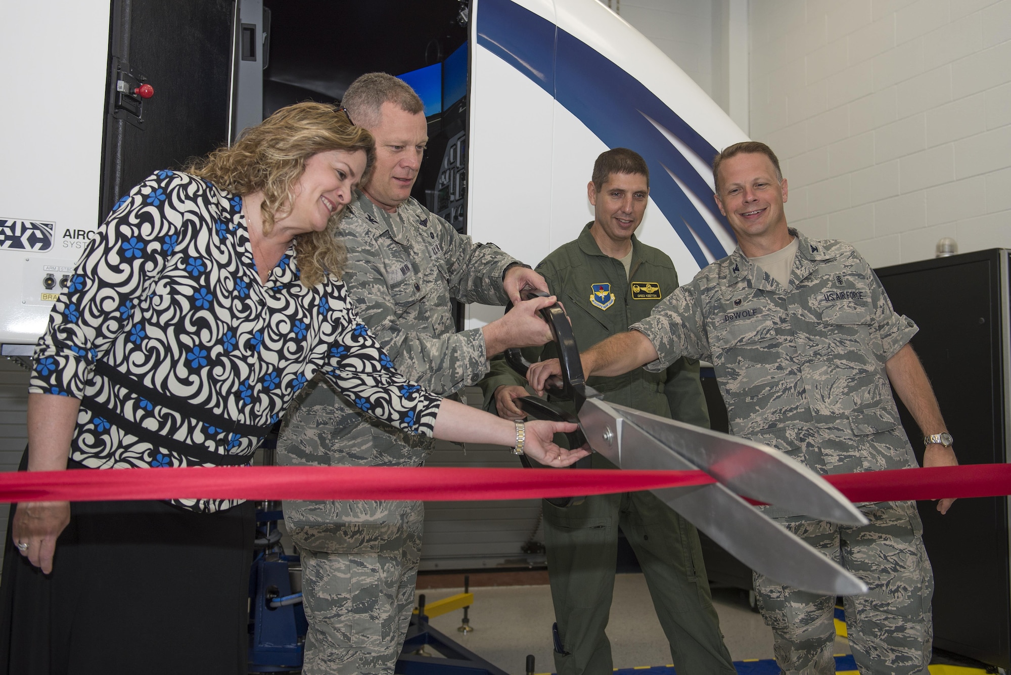 U.S. Air Force Col. Samuel Milam, Air Education and Training Command eputy director of intelligence operations and nuclear intelligence for flying training, (left), cuts the ribbon for AETC’s first Spatial Disorientation Trainer beside Valerie Dahlem, from the Air Force Life Cycle Management Center, (far left), Col. Gregory Keeton, 80th Flying Training Wing commander, (right), and Col. Gregory DeWolf, 82nd Medical Group commander, (far right), at Sheppard Air Force Base May 7, 2015. The trainer simulates different air sicknesses that pilots may experience when flying. Instructors have the ability to walk student pilots through these experiences, teaching them how to combat the disorientation effectively. (U.S. Air Force photo by Senior Airman Kyle Gese/Released)