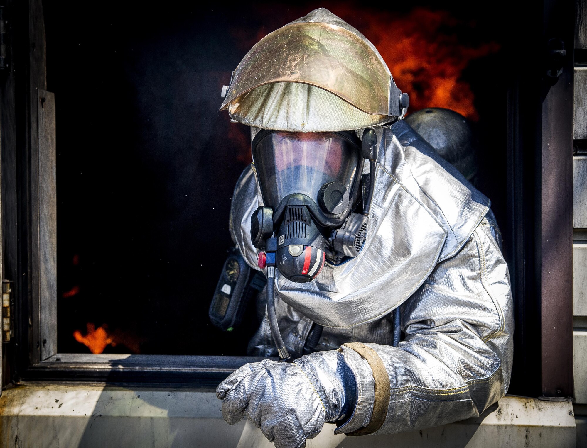 Tech Sgt. Aaron Bebernitz, 315th Civil Engineering Flight fire prevention operations chief, gives visual confirmation of rollover fire prior to extinguishing it during routine training May 2, 2015, at Joint Base Charleston, S.C. After multiple dry runs, the proficiency training of live structural fires is conducted twice a year and tests the firefighters ability to extinguish flames. (U.S. Air Force photo / Senior Airman Tom Brading)