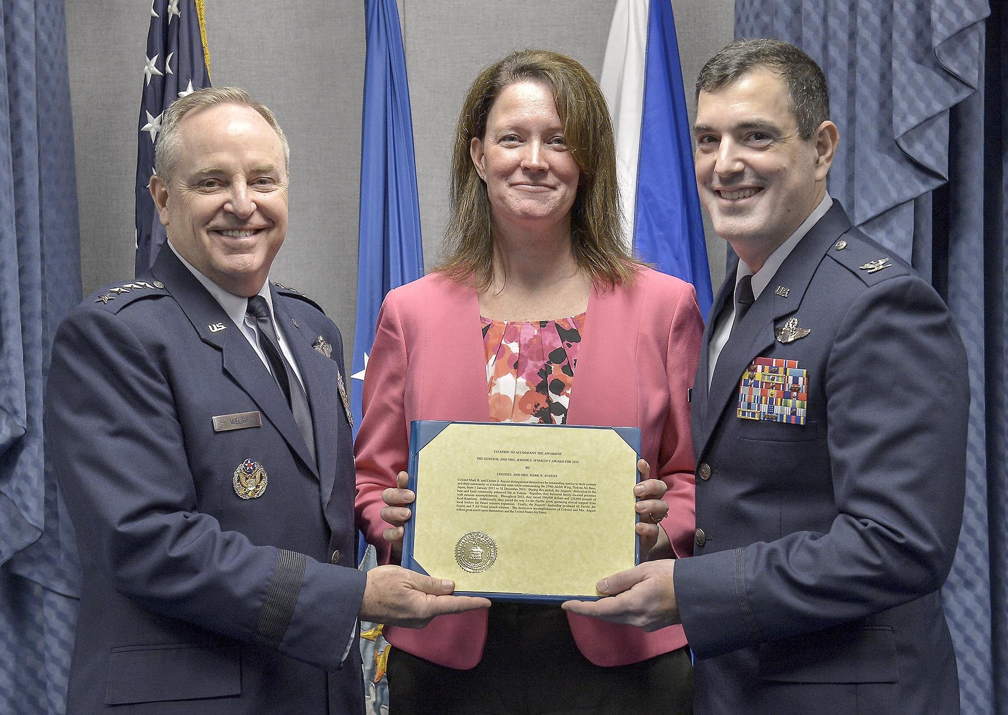 Air Force Chief of Staff Gen. Mark A. Welsh III presents the 2014 General and Mrs. Jerome F. O'Malley Award to Col. and Mrs. Mark August in the Pentagon May 8, 2015, in Washington The annual award recognizes the wing commander and spouse team whose contribution to the nation, Air Force, and local community best exemplifies the highest ideals and positive leadership of a military couple in a key Air Force position.  Col. and Mrs. August received the award for their time as the commander and spouse at the 374th Airlift Wing, Yokota Air Base, Japan.  (U.S. Air Force Photo/Michael J. Pausic)