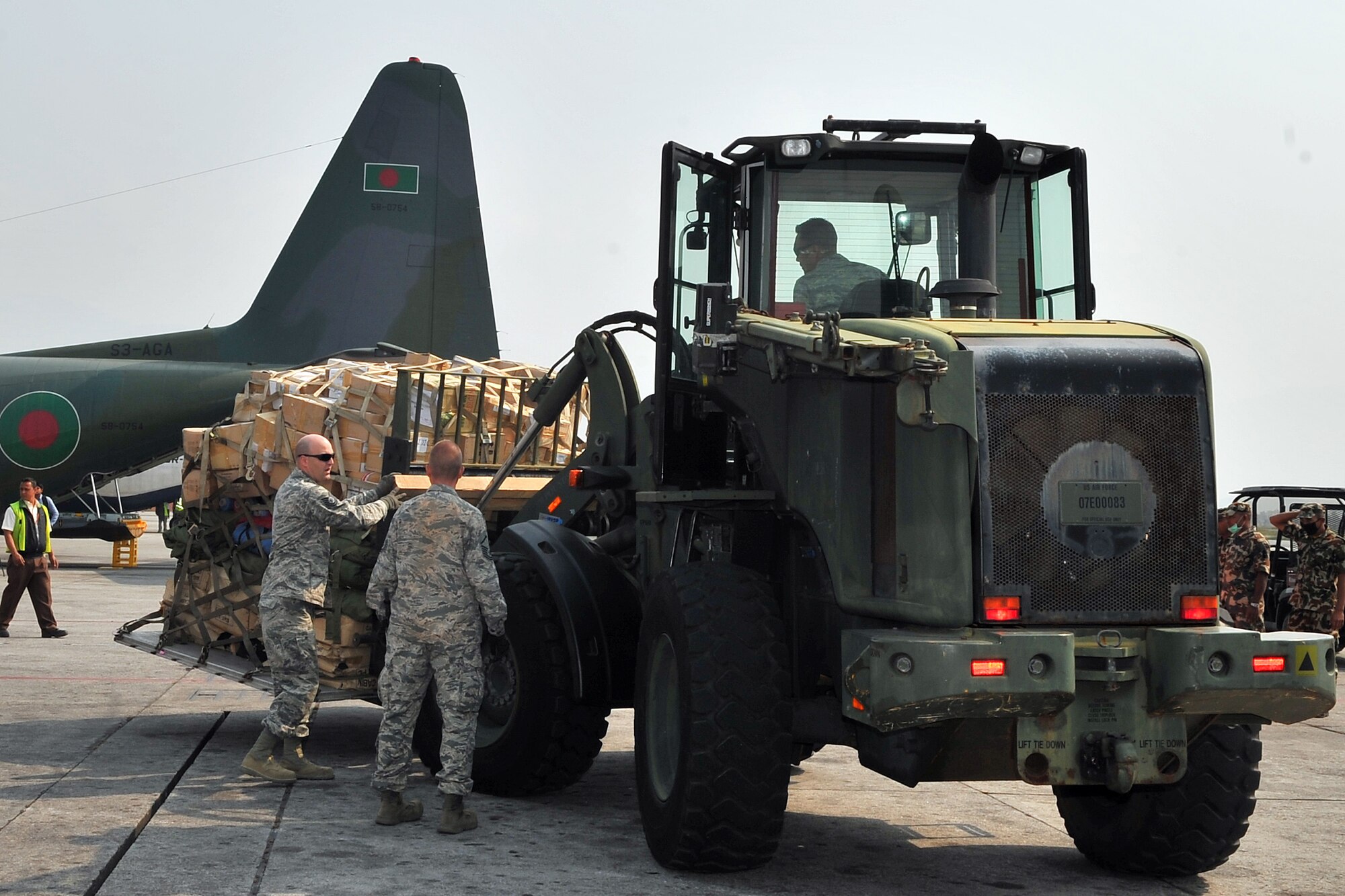 36th Contingency Response Group Airmen process relief supplies from a Bangladesh Air Force C-130 Hercules May 7, 2015, at the Tribhuvan International Airport in Kathmandu, Nepal. The Nepalese Army and Airmen worked with military members from the Bangladesh Air Force and Indian Air Force to process cargo from their aircraft arriving in Nepal to provide disaster relief following a magnitude 7.8 earthquake that struck the nation April 25. (U.S. Air Force photo by Staff Sgt. Melissa White/Released)