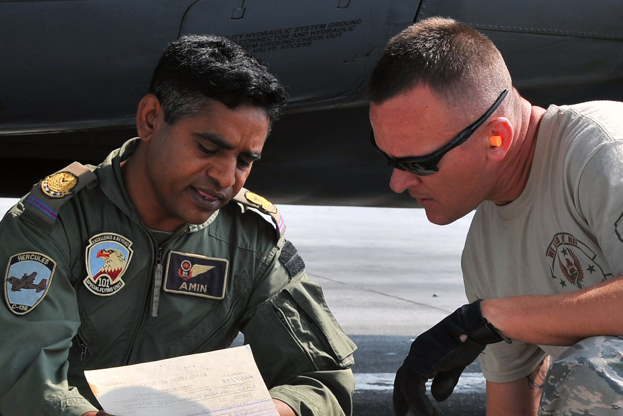 U.S. Air Force Tech. Sgt. Randy Walgren, 36th Mobility Response Squadron NCO in charge of aerial port operations, reviews a cargo manifest with a Bangladesh Air Force member after offloading relief supplies from their C-130 Hercules May 7, 2015 at the Tribhuvan International Airport in Kathmandu, Nepal. The Nepalese Army and Airmen worked with military members from the Bangladesh Air Force and Indian Air Force to process cargo from their aircraft arriving in Nepal to provide disaster relief following a magnitude 7.8 earthquake that struck the nation April 25. (U.S. Air Force photo by Staff Sgt. Melissa White/Released)
