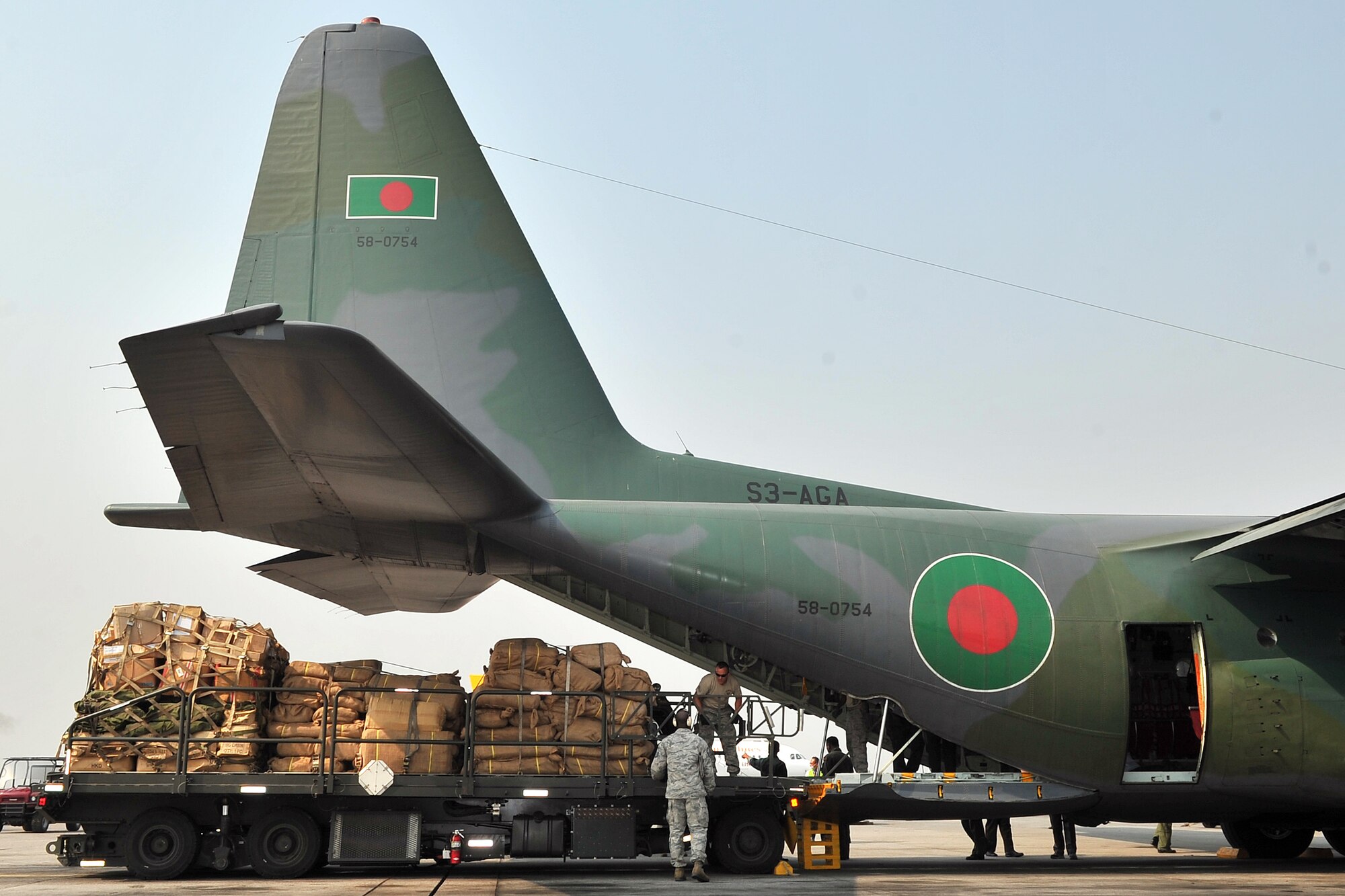 36th Contingency Response Group Airmen work with Bangladesh Air Force members to remove cargo from their C-130 Hercules May 7, 2015, at the Tribhuvan International Airport in Kathmandu, Nepal. The Nepalese Army and Airmen worked with military members from the Bangladesh Air Force and Indian Air Force to process cargo from their aircraft arriving in Nepal to provide disaster relief following a magnitude 7.8 earthquake that struck the nation April 25.  (U.S. Air Force photo by Staff Sgt. Melissa White/Released)