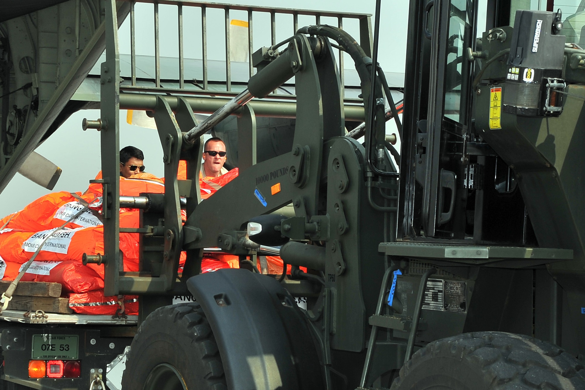 U.S. Air Force Tech. Sgt. Randy Walgren (right), 36th Mobility Response Squadron NCO in charge of aerial port operations, and a Bangladesh Air force member push relief supplies onto a forklift May 7, 2015, at the Tribhuvan International Airport in Kathmandu, Nepal. The Nepalese Army and Airmen worked with military members from the Bangladesh Air Force and Indian Air Force to process cargo from their aircraft arriving in Nepal to provide disaster relief following a magnitude 7.8 earthquake that struck the nation April 25.  (U.S. Air Force photo by Staff Sgt. Melissa White/Released)