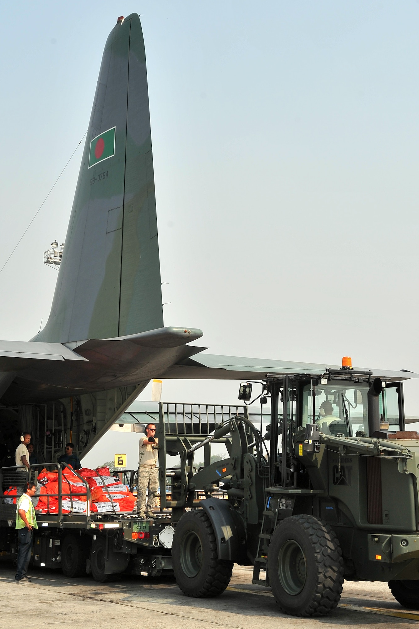 36th Contingency Response Group Airmen work with Bangladesh Air Force members to remove relief supplies from their C-130 Hercules May 7, 2015, at the Tribhuvan International Airport in Kathmandu, Nepal. The Nepalese Army and Airmen worked with military members from the Bangladesh Air Force and Indian Air Force to process cargo from their aircraft arriving in Nepal to provide disaster relief following a magnitude 7.8 earthquake that struck the nation April 25. (U.S. Air Force photo by Staff Sgt. Melissa White/Released)