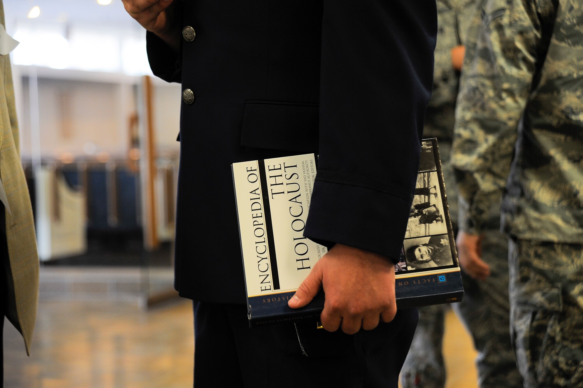 U.S. Air Force 2nd Lt Charles Hulsizer, 355th Force Support Squadron,  holds the "Encyclopedia of the Holocaust" during the Holocaust Day of Remembrance at Davis-Monthan Air Force Base, Ariz., May 7, 2015. Six holocaust survivors spoke to over 90 people about their personal experiences and survival during the Holocaust.  (U.S. Air Force photo by Staff Sgt. Angela Ruiz/Released) 