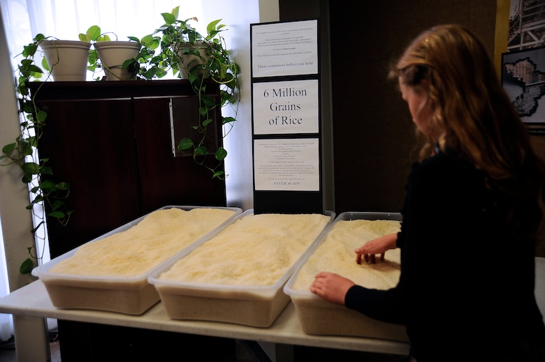 A young girl touches grains of rice which represent the 6 million Jews who died in the Holocaust during the Holocaust Day of Remembrance at Davis-Monthan Air Force Base, Ariz., May 7, 2015. It is estimated that more than 10 million people lost their lives as a result of the Holocaust. (U.S. Air Force photo by Staff Sgt. Angela Ruiz) 