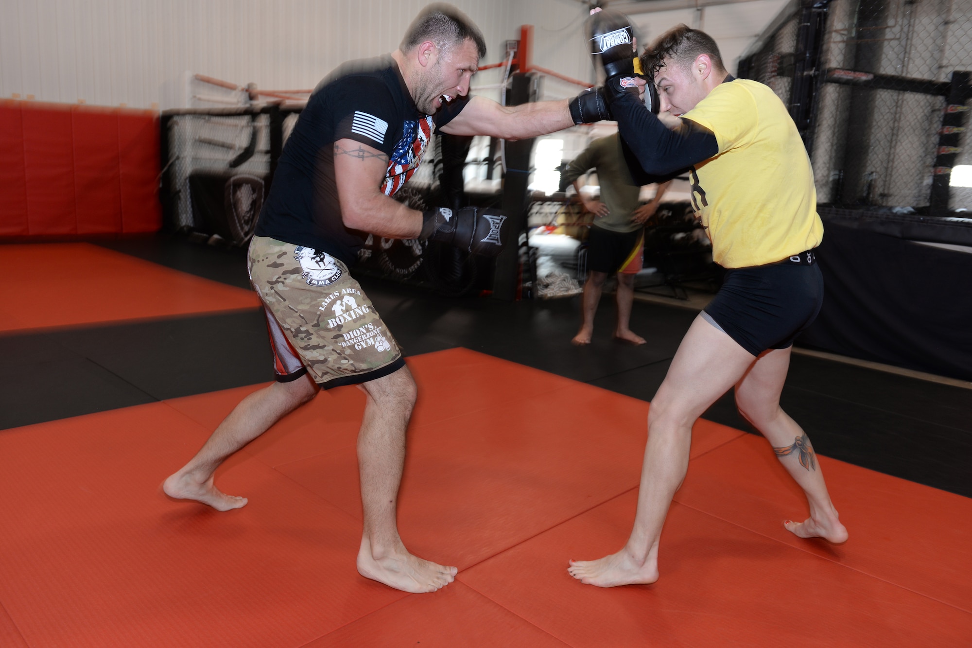 119th Security Forces members from left to right Tech. Sgt. Gemenie Strehlow and Senior Airman Michael Bullen exchange punches as they spar while training at a Fargo, North Dakota, gym May 8, 2015. The security forces Airmen are training at the gym to enhance their fitness and skills to be better prepared in their career field for potential threats on duty. Bullen is scheduled for a competitive mixed martial arts match May 16 in Detroit Lakes, Minnesota. (U.S. Air National Guard photo by Senior Master Sgt. David H. Lipp/Released)