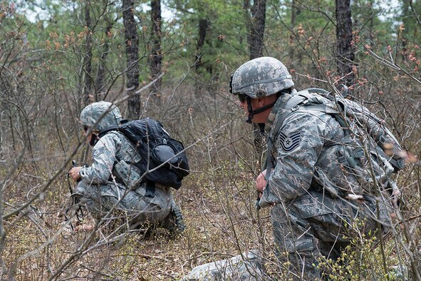 U.S. Air Force Tech. Sgt. Jack Carr, 87th Security Forces Squadron military working dog handler, warns opposition forces of imminent K9 attack during a field training exercise on Joint Base McGuire-Dix-Lakehurst, N.J. May 6, 2015. The military working dog handlers came to support the 87th Civil Engineer Squadron Explosive Ordnance Disposal team during the exercise, working side-by-side as they would downrange. (U.S. Air Force photo by Airman 1st Class Joshua King) 