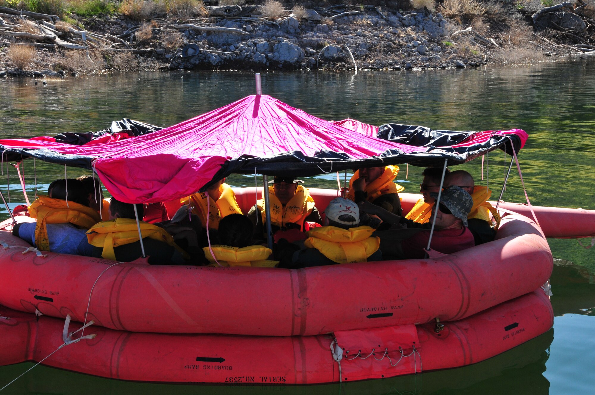 Airmen from the 161st Air Refueling Wing float in their 20 man life raft after rolling the sides of the canopy up for ventilation during water survival training at Lake Pleasant, Peoria, Ariz., May 3, 2015. Water survival training encompasses equipment familiarization and processes in the event of an emergency over-water ditching scenario.    (U.S. Air National Guard photo by Master Sgt. Kelly M. Deitloff)