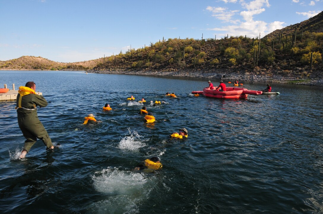 Airmen from the 161st Air Refueling Wing jump into Waddell Cove to simulate exiting an aircraft that has landed in the water during water survival training May 3, 2015, at Lake Pleasant, Peoria, Ariz. Water survival training encompasses equipment familiarization and processes in the event of an emergency over-water ditching scenario.    (U.S. Air National Guard photo by Master Sgt. Kelly M. Deitloff)