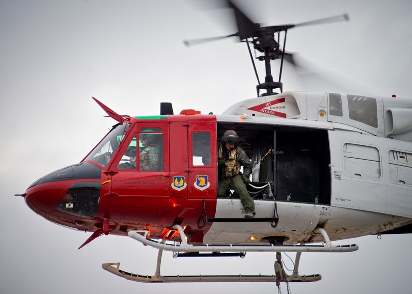 An 413th Flight Test Squadron UH-1 Huey aircrew member keeps an eye on a dangling water bucket during a training mission at Eglin Air Force Base, Fla.  The water bucket operations training is required for flight crews to maintain their firefighting proficiencies.  The 413th helicopters can be tasked by the 96th Test Wing to support Jackson Guard with fire management.  They supported a firefighting effort during a range fire North of Hurlburt Field in May 2012. (U.S. Air Force photo/Samuel King Jr.)