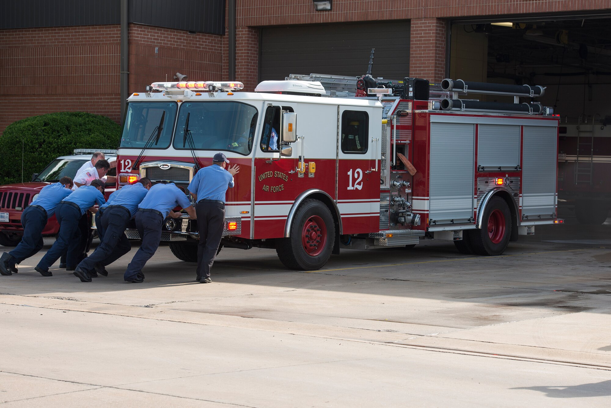 U.S. Air Force firefighters from the 82nd Training Wing push a new Protection-22 engine into the fire station at Sheppard Air Force Base, Texas, during a housing ceremony May 8, 2015. The ceremony welcomed the new engine to the fleet which was part of the fire department’s vehicle replacement program. (U.S. Air Force photo by Senior Airman Kyle Gese/Released)