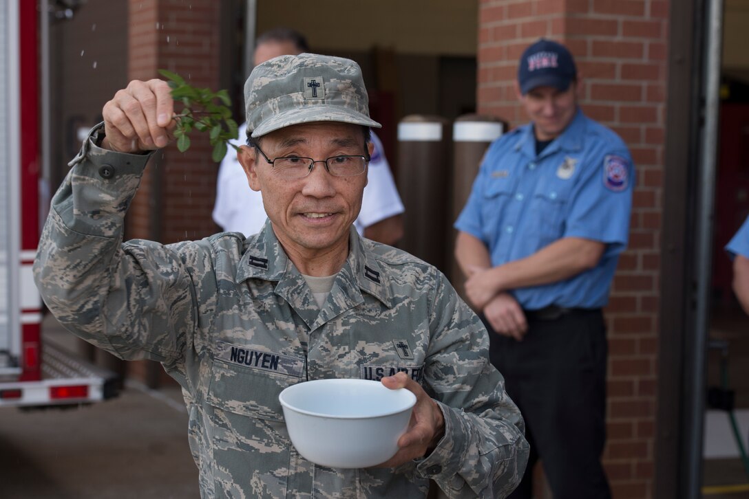 U.S. Air Force Capt. Hung Nguyen, 82nd Training Wing chaplain, blesses the 82nd TRW firefighters as well as a new Protection-22 engine at Sheppard Air Force Base, Texas, May 8, 2015. The firefighters took part in welcoming the new engine to the fleet during the housing ceremony as part of a long-standing tradition. Dating back to the mid-1800s, firefighters had to push their wagon backwards into the station because their horses could not push backwards. (U.S. Air Force photo by Senior Airman Kyle Gese/Released)