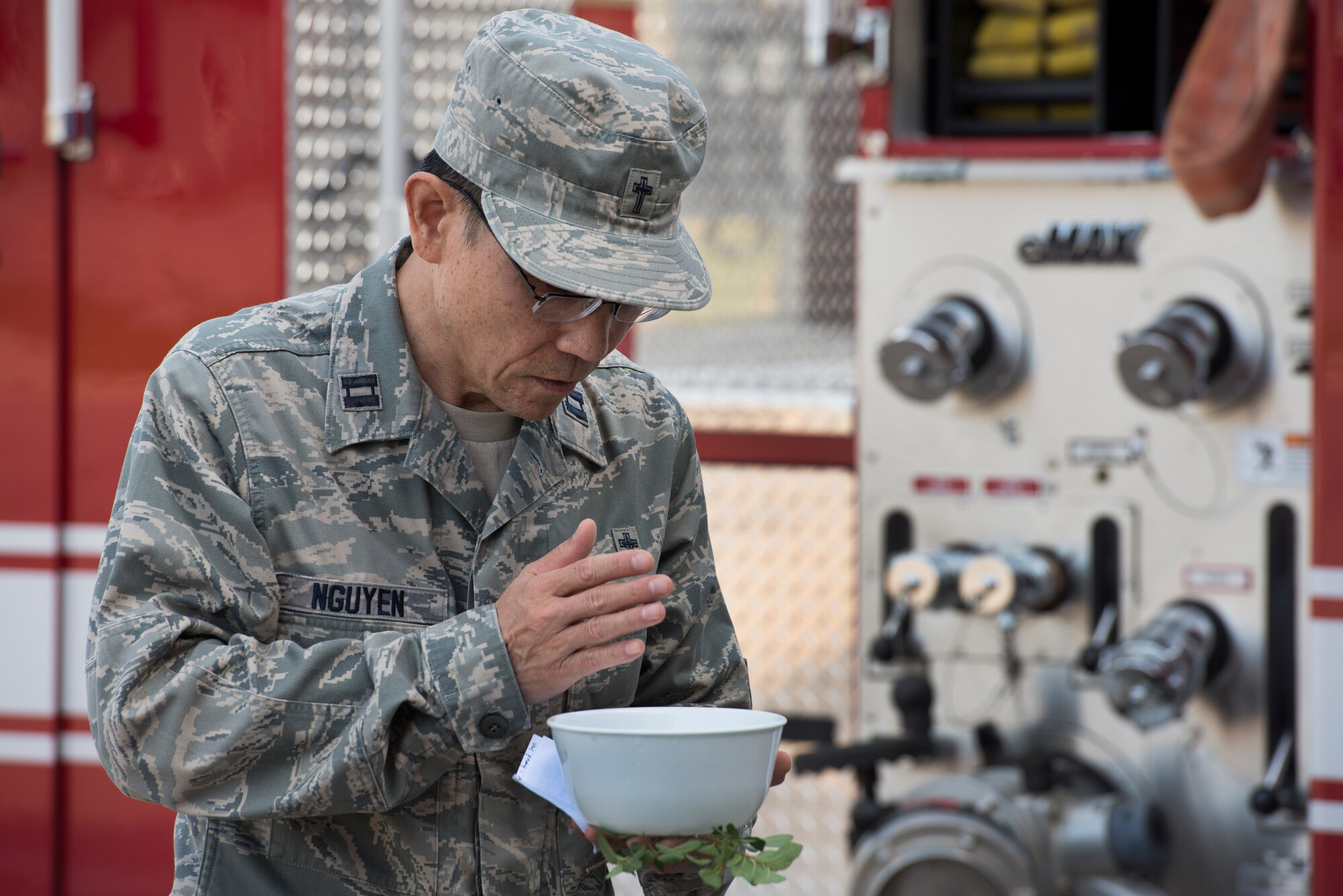U.S. Air Force Capt. Hung Nguyen, 82nd Training Wing chaplain, blesses a bowl of water to be used in a housing ceremony at Sheppard Air Force Base, Texas, May 8, 2015. The ceremony took place to welcome a new fire engine to the fleet. The newly added truck has the capability to house five firefighters, increasing the overall readiness of the 82nd TRW fire department. (U.S. Air Force photo by Senior Airman Kyle Gese/Released)