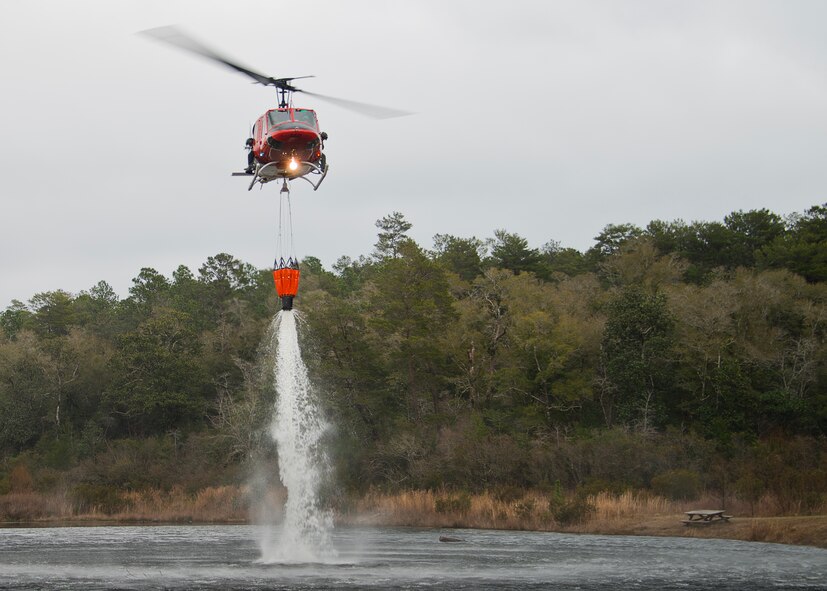 A 413th Flight Test Squadron UH-1 Huey drops water back into Anderson Pond during a training mission at Eglin Air Force Base, Fla.  The water bucket operations training is required for flight crews to maintain their firefighting proficiencies.  The 413th helicopters can be tasked by the 96th Test Wing to support Jackson Guard with fire management.  They supported a firefighting effort during a range fire North of Hurlburt Field in May 2012. (U.S. Air Force photo/Samuel King Jr.)