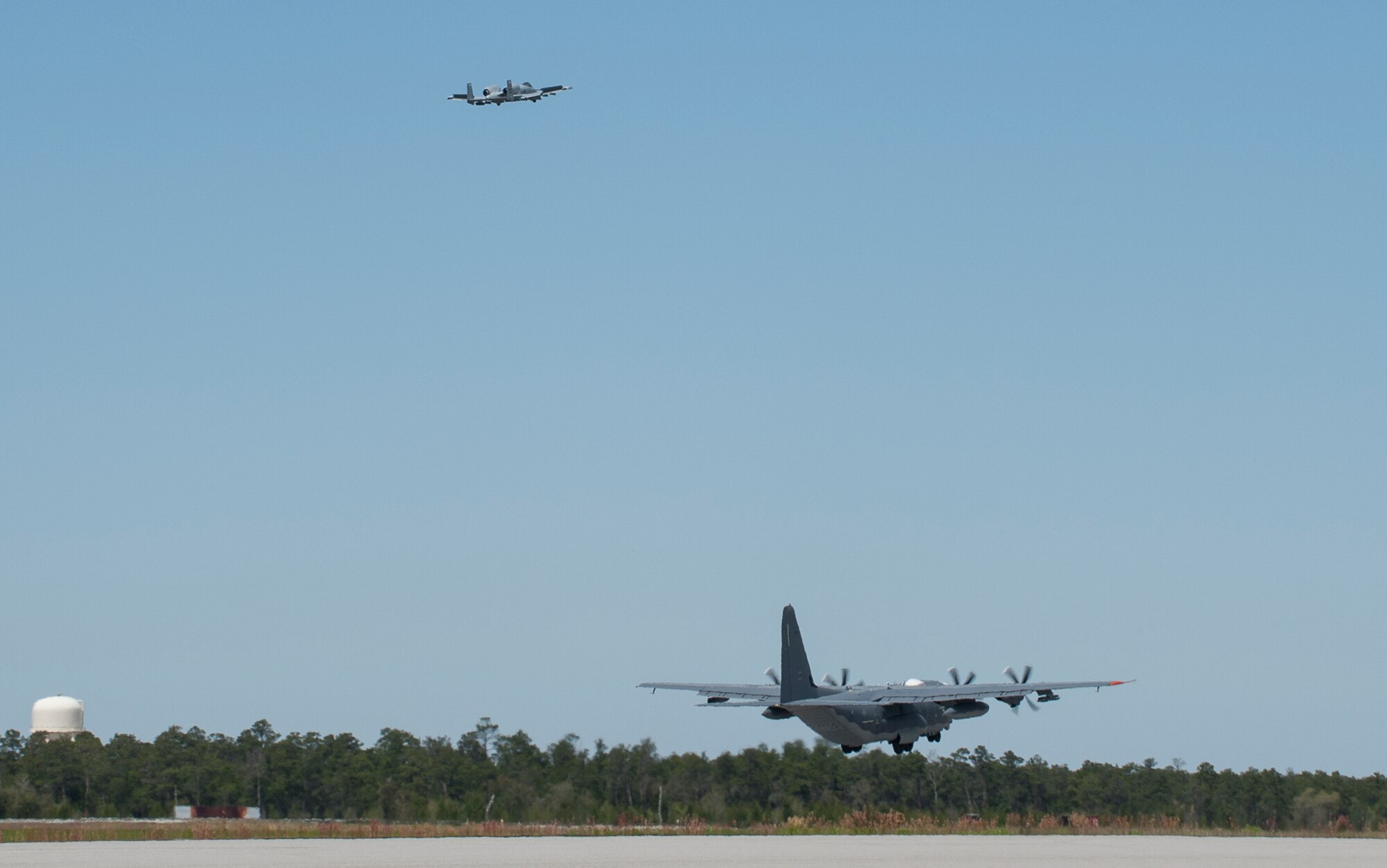 An A-10C Thunderbolt II flies above an AC-130J Ghostrider, after performing an “aerial pick-up” at Eglin Air Force Base, Fla., March 27.  The A-10 acted as a safety chase for an AC-130 that performed dynamic maneuvers to assess the aircraft’s flight qualities.  These aircraft are used for developmental tests that provide flight data.  The 413th Flight Test Squadron plans, executes and reports development tests and evaluations of the Air Force’s Special Operations Command’s aircraft as well as the Air Force’s vertical lift aircraft.  (U.S. Air Force photo/Ilka Cole) 