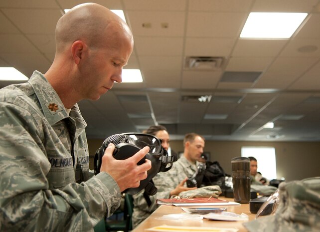 Chaplain (Maj.) Rolf Holmquist, 99th Air Base Wing deputy chaplain, inspects a gas mask during a chemical, biological, radiological and nuclear defense survival skills training course on Nellis Air Force Base, Nev., April 30, 2015. A gas mask inspection should be performed every six months when not in a combat zone or every seven days while in a combat zone. (U.S. Air Force photo by Airman 1st Class Mikaley Towle)