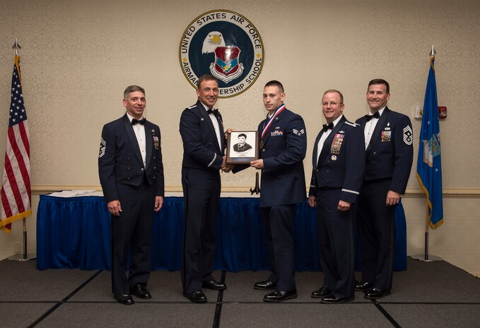 Command Chief Master Sgt. Shawn Hughes, Col. John Lamontagne, Col. Jeffrey DeVore and Command Chief Master Sgt. Mark Bronson pose for a group photo with Senior Airman Bennie Rizzo, from the 437th Maintenance Squadron who was awarded the John L. Levitow award May 7, 2015, at Joint Base Charleston, S.C., during the Airman Leadership School Class XXX graduation. The John L. Levitow award is given for a student’s exemplary demonstration of excellence, both as a leader and a scholar. Hughes is the 437th Airlift Wing command chief, Lamontagne is the 437th AW commander, Devore is the JB Charleston commander and Bronson is the 628th Air Base Wing command chief. (U.S. Air Force photo/Senior Airman Jared Trimarchi)  